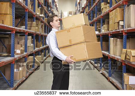 Stock Photo - Man Carrying Boxes In Warehouse . Fotosearch