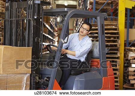 Picture - Man Driving Fork Lift Truck In Warehouse. Fotosearch