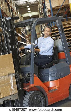 Stock Photo - Man Driving Fork Lift Truck In Warehouse. Fotosearch