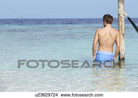 Picture - Man Standing In Beautiful Tropical Sea. Fotosearch