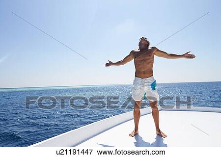 Stock Photo - Man Standing On Deck Of Boat. Fotosearch