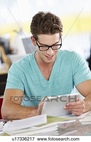 Man Using Digital Tablet In Busy Creative Office View Large Photo Image Stock Photo - Man Using Digital Tablet In Busy Creative Office. Fotosearch