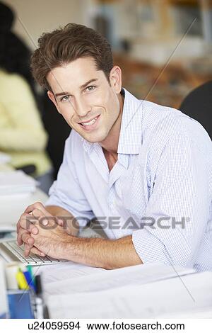 Picture - Man Working At Desk In Busy Creative Office. Fotosearch