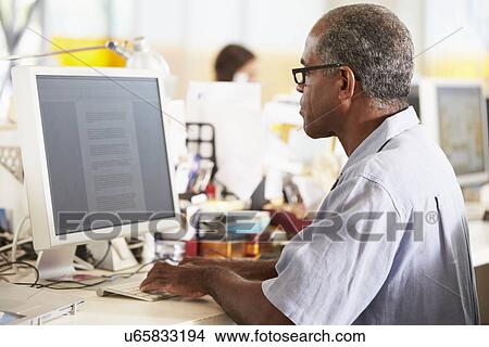 Man Working At Desk In Busy Creative Office View Large Photo Image Picture - Man Working At Desk In Busy Creative Office. Fotosearch