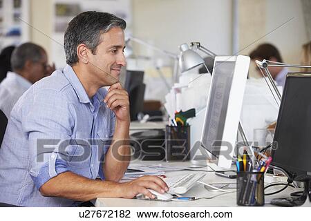 Man Working At Desk In Busy Creative Office View Large Photo Image Stock Image - Man Working At Desk In Busy Creative Office. Fotosearch