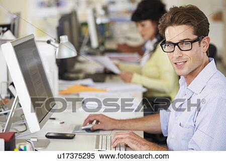 Man Working At Desk In Busy Creative Office View Large Photo Image Stock Photography - Man Working At Desk In Busy Creative Office. Fotosearch