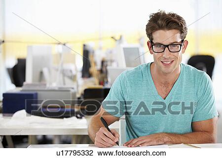 Man Writing At Desk In Busy Creative Office Stock Image Writing At Desk In Busy Creative Office