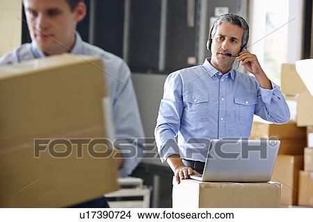 Picture - Manager Using Headset In Distribution Warehouse. Fotosearch