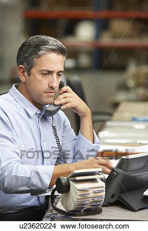 Manager Working At Desk In Warehouse View Large Photo Image Picture - Manager Working At Desk In Warehouse. Fotosearch