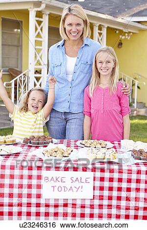 Stock Photograph - Mother And Children Running Charity Bake Sale. Fotosearch