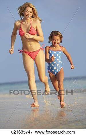 Stock Photo - Mother And Daughter Having Fun In Sea On Beach Holiday. Fotosearch