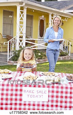 Stock Image - Mother And Daughter Running Charity Bake Sale. Fotosearch