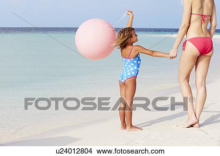 Picture - Mother And Daughter Running On Beautiful Beach With Balloon. Fotosearch