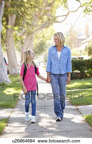 Mother And Daughter Walking To School On Suburban Street View Large Photo Image Picture - Mother And Daughter Walking To School On Suburban Street. Fotosearch