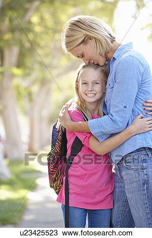 Stock Image - Mother And Daughter Walking To School On Suburban Street. Fotosearch
