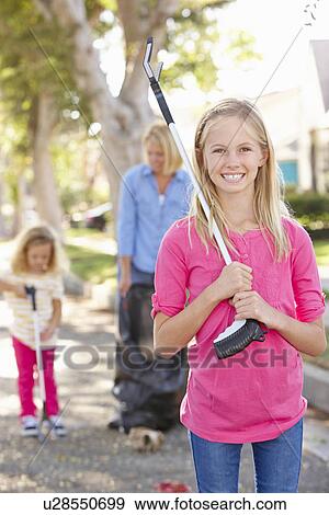Stock Photo - Mother And Daughters Picking Up Litter In Suburban Street. Fotosearch