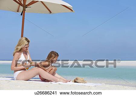 Mother Protecting Daughter With Sun Lotion On Beach Holiday View Large Photo Image Stock Image - Mother Protecting Daughter With Sun Lotion On Beach Holiday. Fotosearch