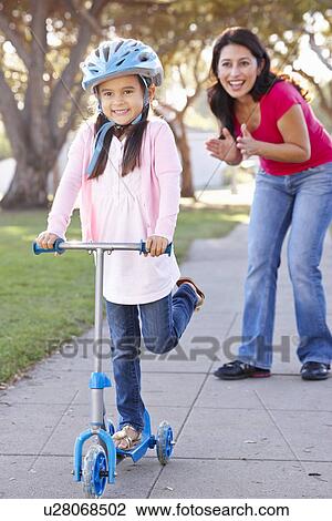 Mother Teaching Daughter To Ride Scooter View Large Photo Image Stock Image - Mother Teaching Daughter To Ride Scooter. Fotosearch