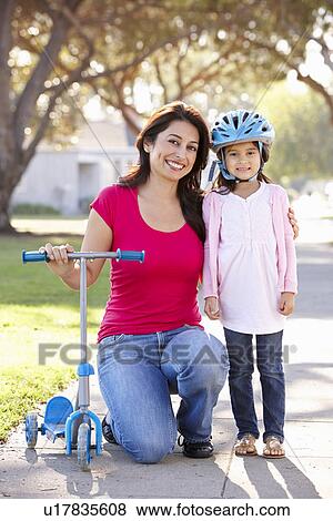 Mother Teaching Daughter To Ride Scooter View Large Photo Image Stock Photo - Mother Teaching Daughter To Ride Scooter. Fotosearch