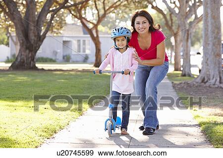 Mother Teaching Daughter To Ride Scooter View Large Photo Image Stock Photo - Mother Teaching Daughter To Ride Scooter. Fotosearch