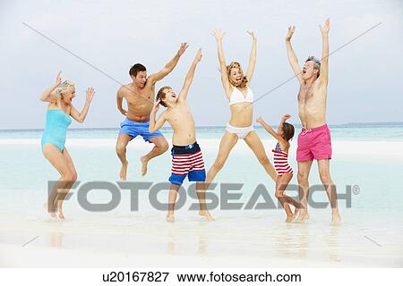Stock Photo - Multi Generation Family Having Fun In Sea On Beach Holiday. Fotosearch
