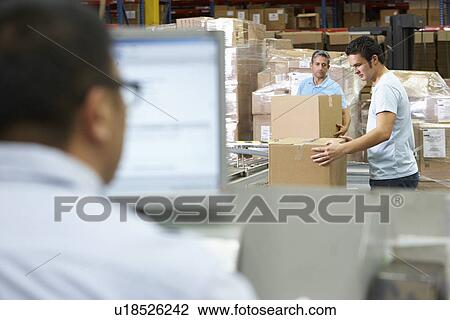 Stock Image - Person At Computer Terminal In Distribution Warehouse. Fotosearch