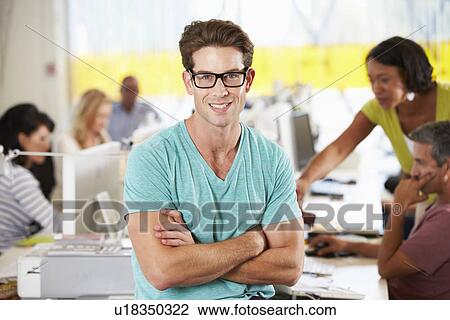 Portrait Of Man Standing In Busy Creative Office View Large Photo Image Stock Image - Portrait Of Man Standing In Busy Creative Office. Fotosearch
