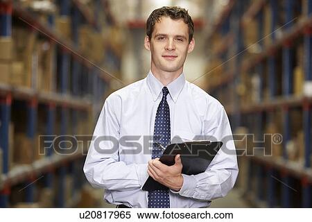 Stock Photography - Portrait Of Manager In Warehouse With Clipboard. Fotosearch
