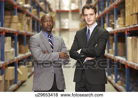 Stock Photo - Portrait Of Two Businessmen In Warehouse. Fotosearch