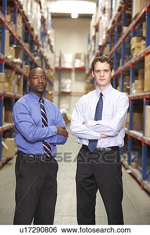 Stock Photograph - Portrait Of Two Businessmen In Warehouse. Fotosearch