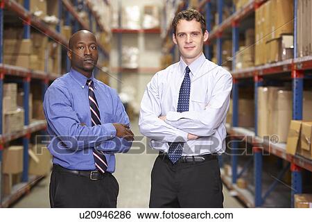 Stock Photograph - Portrait Of Two Businessmen In Warehouse. Fotosearch