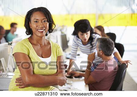 Portrait Of Woman Standing In Busy Creative Office View Large Photo Image Stock Image - Portrait Of Woman Standing In Busy Creative Office. Fotosearch