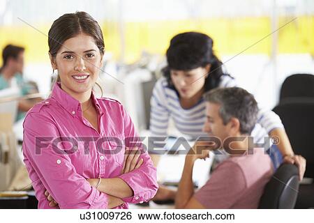 Portrait Of Woman Standing In Busy Creative Office View Large Photo Image Stock Photograph - Portrait Of Woman Standing In Busy Creative Office. Fotosearch