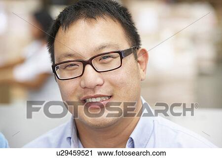 Stock Image - Portrait Of Worker In Distribution Warehouse. Fotosearch
