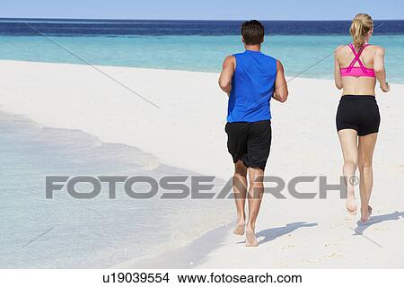 Rear View Of Couple Running On Beautiful Beach View Large Photo Image Picture - Rear View Of Couple Running On Beautiful Beach. Fotosearch