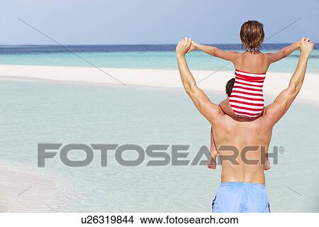 Rear View Of Father Carrying Daughter On Beach Holiday View Large Photo Image Picture - Rear View Of Father Carrying Daughter On Beach Holiday. Fotosearch