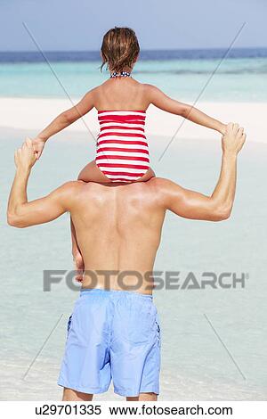 Rear View Of Father Carrying Daughter On Beach Holiday View Large Photo Image Stock Photography - Rear View Of Father Carrying Daughter On Beach Holiday. Fotosearch