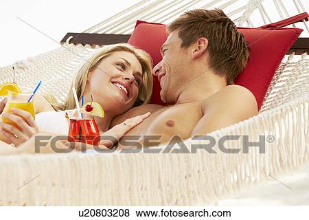 Romantic Couple Relaxing In Beach Hammock View Large Photo Image Stock Photo - Romantic Couple Relaxing In Beach Hammock. Fotosearch