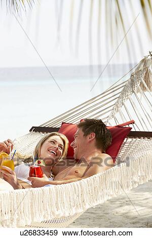 Romantic Couple Relaxing In Beach Hammock View Large Photo Image Stock Photo - Romantic Couple Relaxing In Beach Hammock. Fotosearch