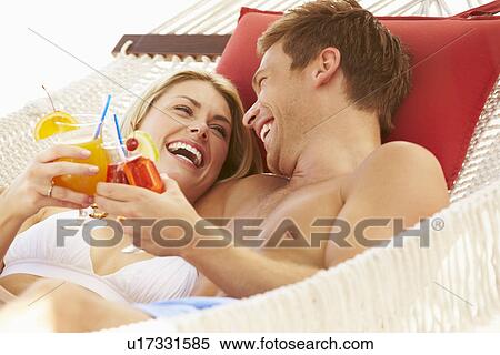 Stock Photography - Romantic Couple Relaxing In Beach Hammock. Fotosearch