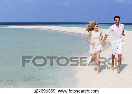 Stock Photo - Romantic Couple Running On Beautiful Tropical Beach. Fotosearch