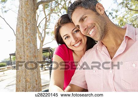 Stock Photography - Romantic Couple Sitting On Park Bench Together. Fotosearch