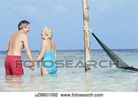 Stock Image - Romantic Senior Couple Standing In Beautiful Tropical Sea. Fotosearch