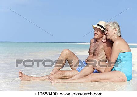 Stock Image - Senior Couple Enjoying Beach Holiday. Fotosearch
