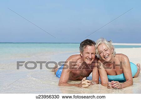 Stock Image - Senior Couple Enjoying Beach Holiday. Fotosearch
