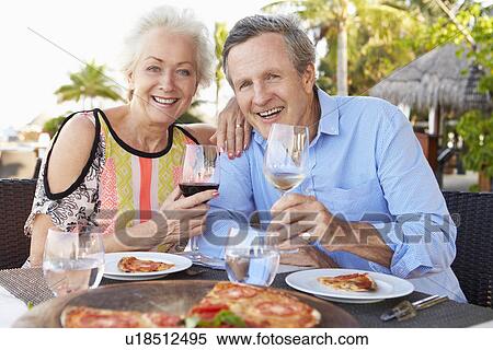Stock Photography - Senior Couple Enjoying Meal In Outdoor Restaurant. Fotosearch