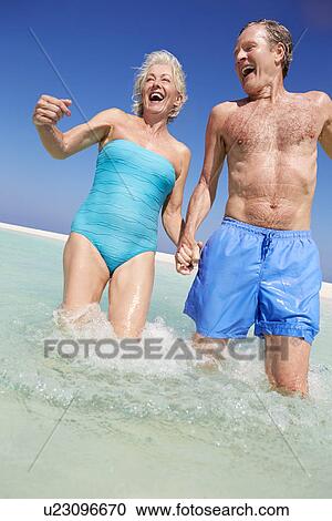Senior Couple Having Fun In Sea On Beach Holiday View Large Photo Image Stock Image - Senior Couple Having Fun In Sea On Beach Holiday. Fotosearch