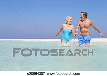 Senior Couple Having Fun In Sea On Beach Holiday View Large Photo Image Stock Photo - Senior Couple Having Fun In Sea On Beach Holiday. Fotosearch
