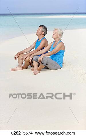 Picture - Senior Couple In Sports Clothing Relaxing On Beautiful Beach. Fotosearch