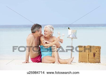 Picture - Senior Couple On Beach With Luxury Champagne Picnic. Fotosearch